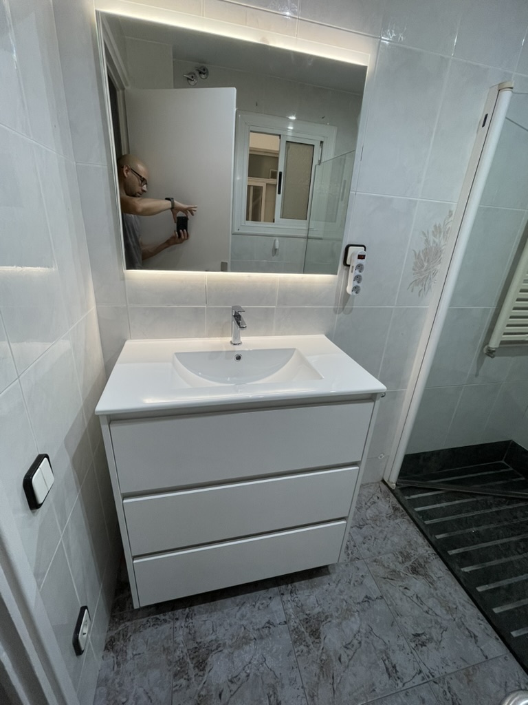 Reforma de baño con mosaico y espejo redondo LED