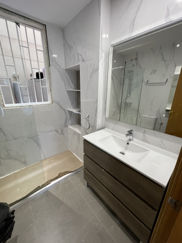 Reforma de baño con mármol blanco y ducha